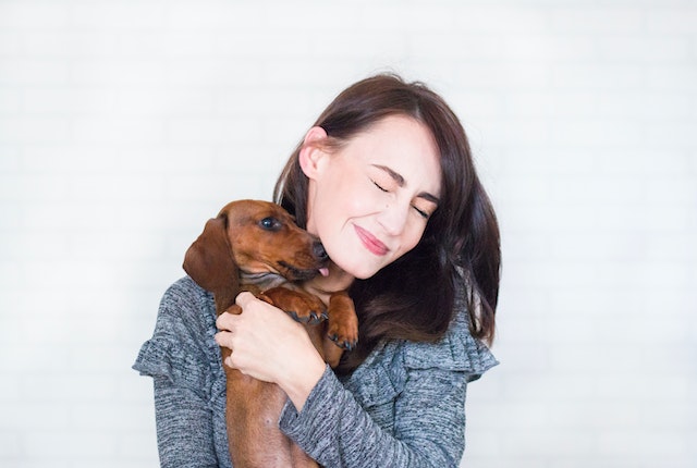 a person holding a brown dog up to their face